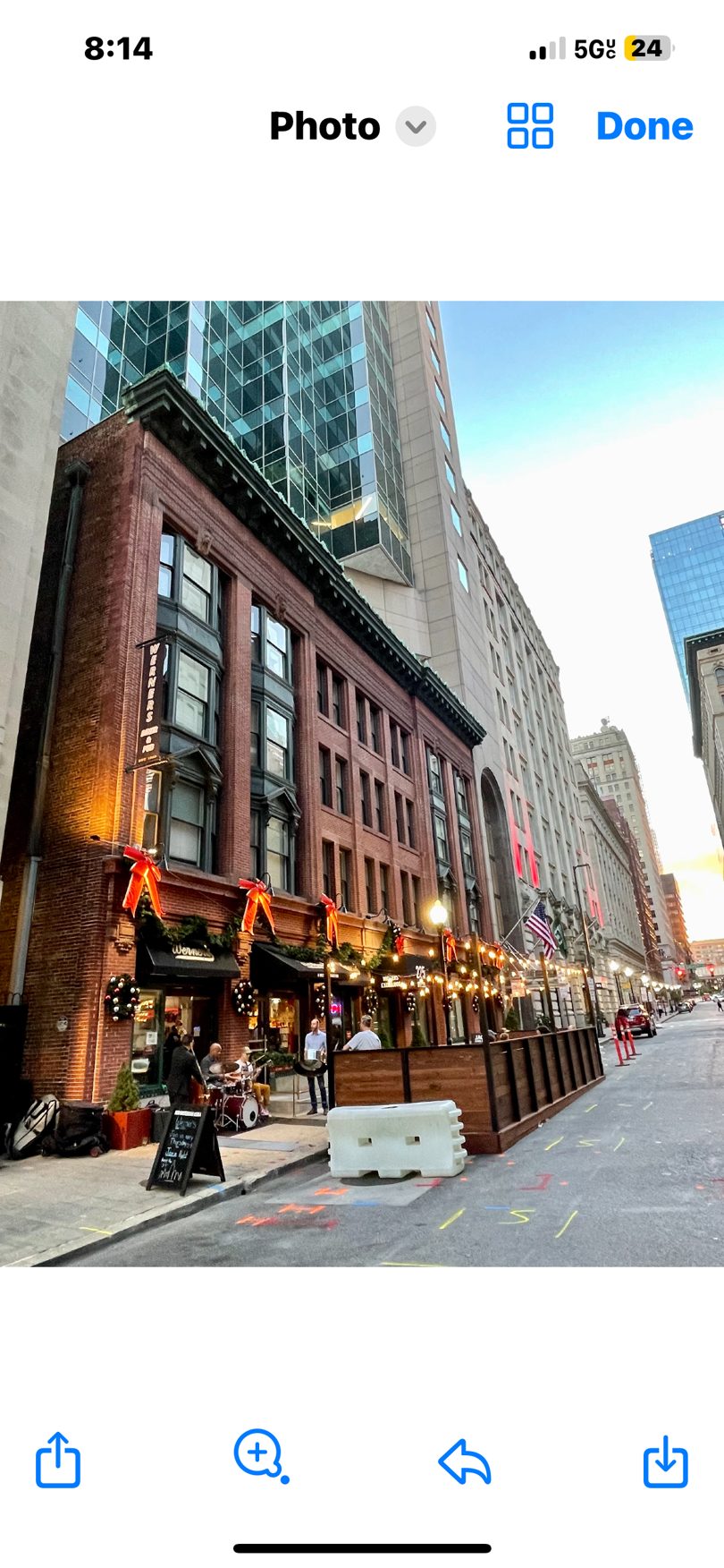 A brick building with a restaurant, outdoor patio, and live band on a city street.