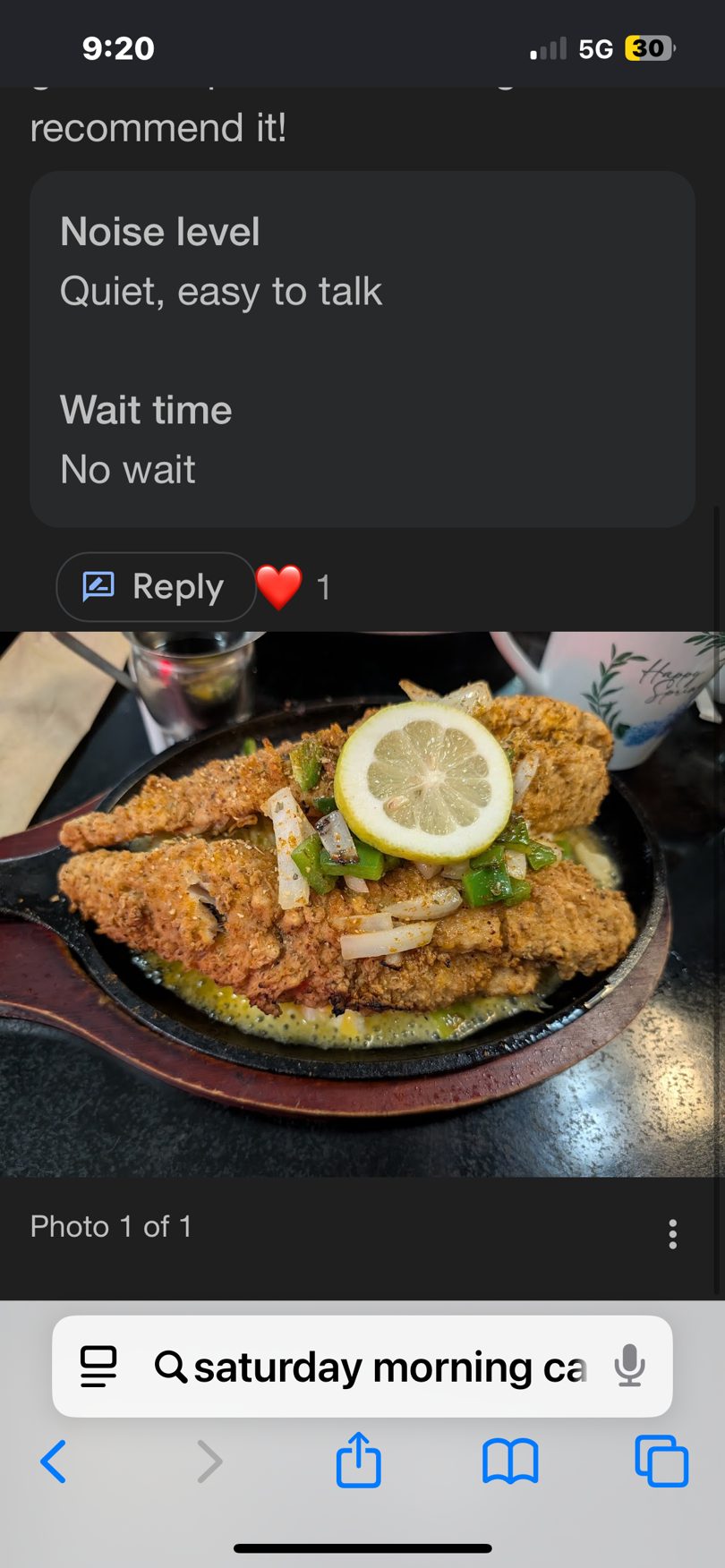 Crispy fried fish fillets topped with sliced lemon, onions, and green peppers in a sizzling skillet.