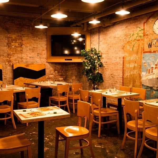 Cozy restaurant interior with exposed brick walls, wooden tables and chairs, and a large mural.
